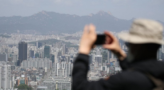 한 시민이 아파트 밀집 지역을 촬영하고 있다. <연합뉴스>
